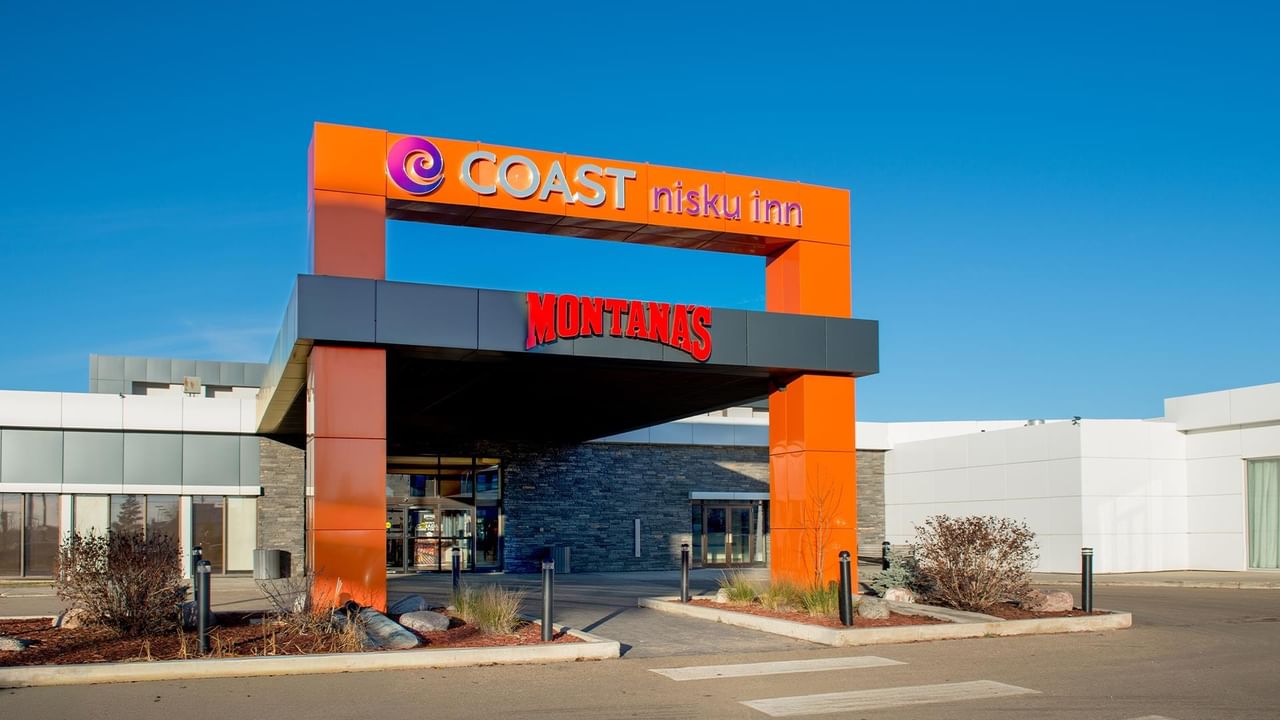 Entrance to Coast Nisku Inn & Conference Centre with clear blue sky above.