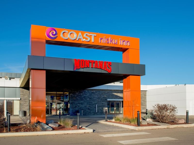 Entrance to Coast Nisku Inn & Conference Centre with clear blue sky above.