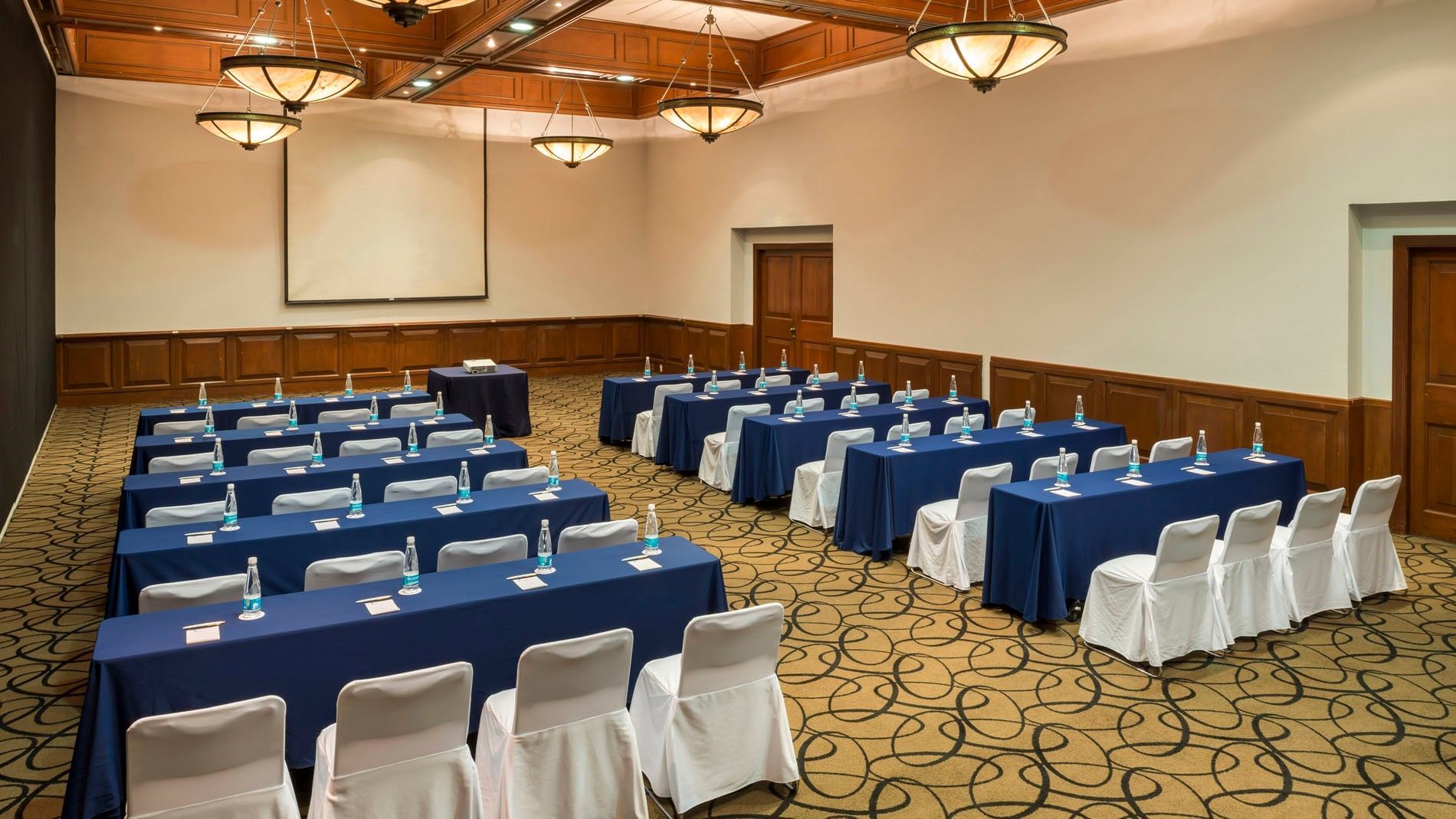 Cantera meeting room set up with blue tables and white-clothed chairs at Camino Real Puebla Angelopolis