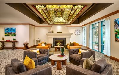 Varscona Hotel lobby with a fireplace, several couches, and a stained glass ceiling.