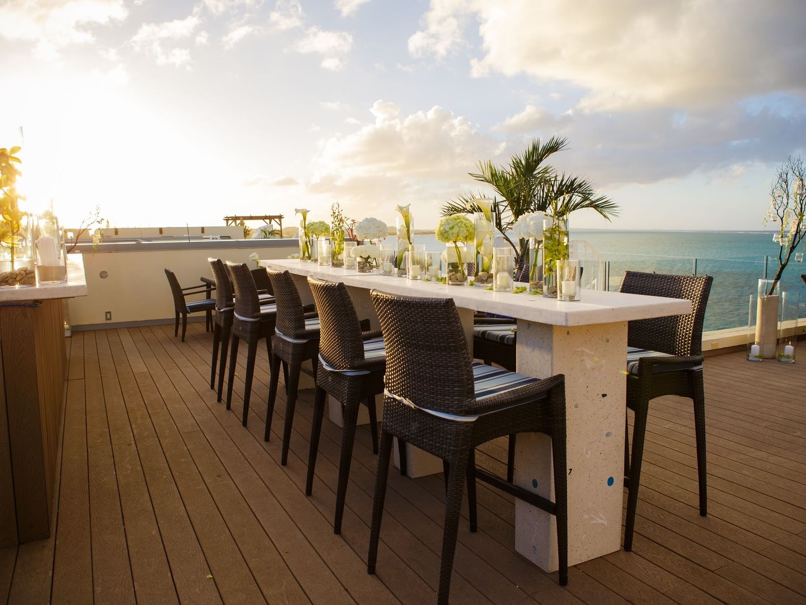 Elegant Penthouse Rooftop Terrace dining with chairs, and candles overlooking the ocean at Windsong Resort On The Reef