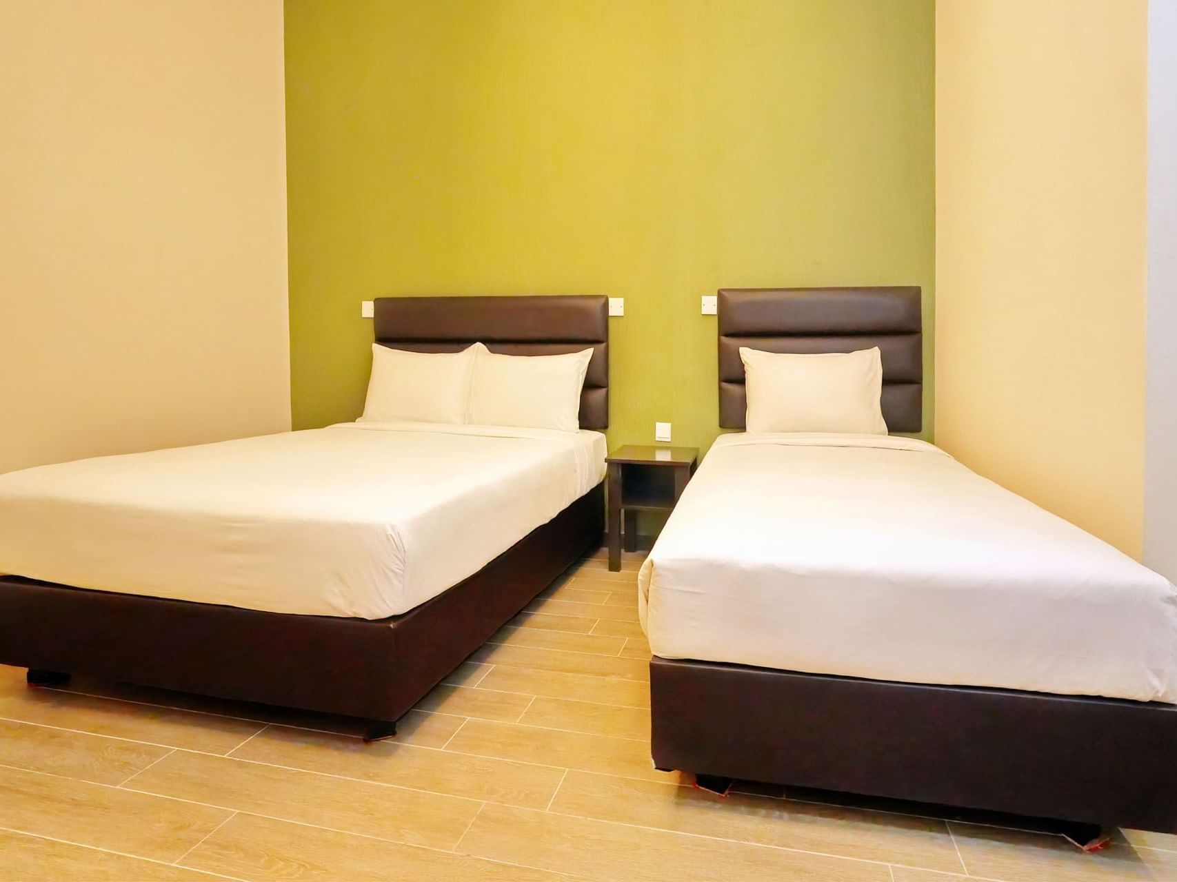 Cozy beds with cushioned headboards in Standard Triple at Cititel Express Ipoh