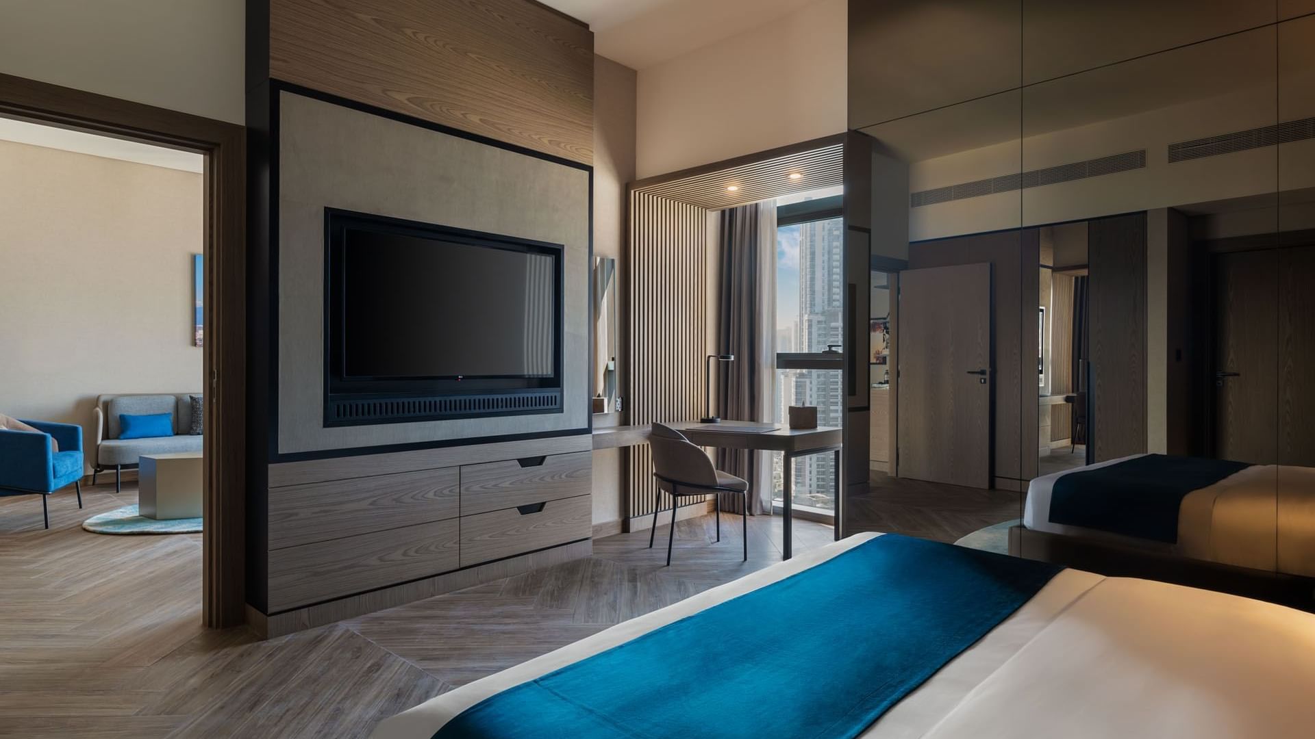 Modern hotel suite with a comfortable bed, workspace, and a glimpse into the living area at Paramount Hotel Midtown