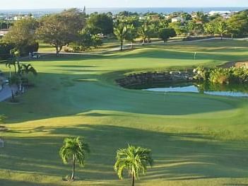 Barbados Golf Club featuring a serene pond and lush green grass near Dover Beach Hotel