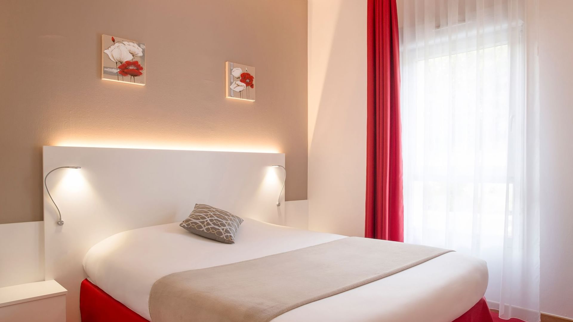 Bed with white & red bedding at Originals Hotels
