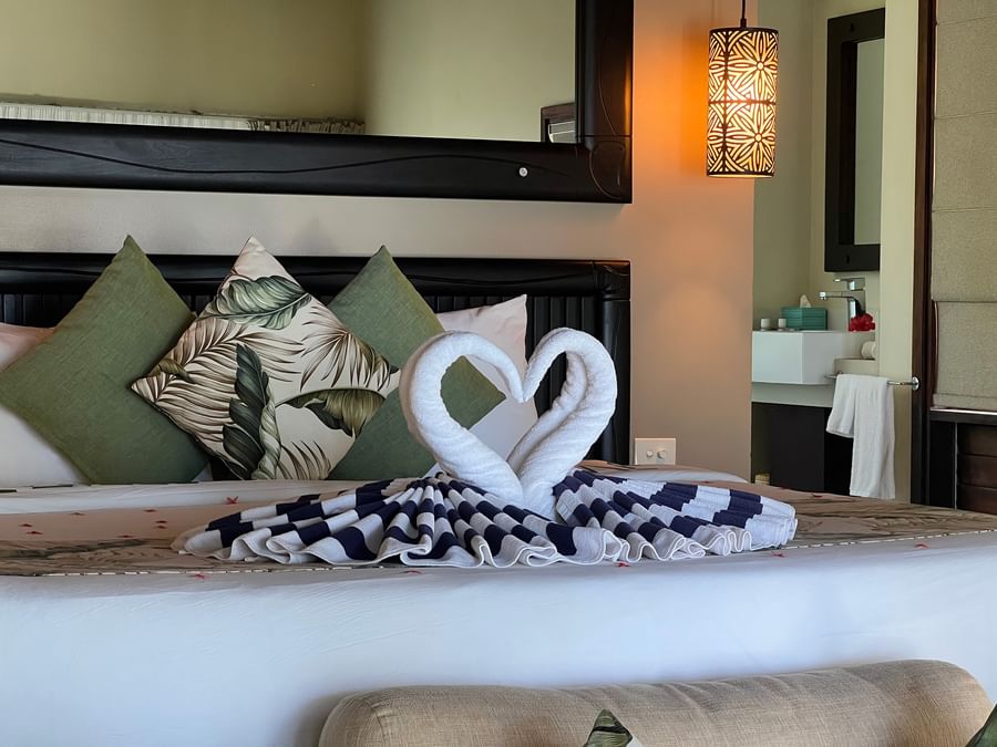 Cozy bedroom with heart-shaped towel arrangement on the bed at Tambua Sands Beach Resort - Fiji.