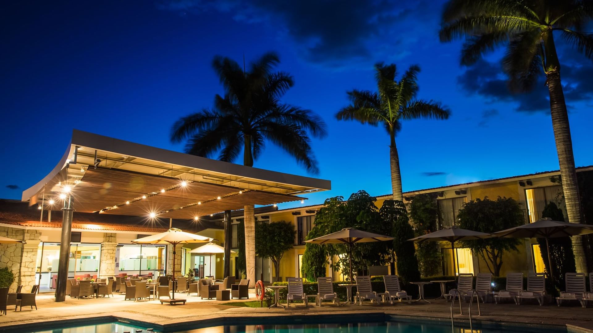 Outdoor dining by the pool at Fiesta Inn Oaxaca at night