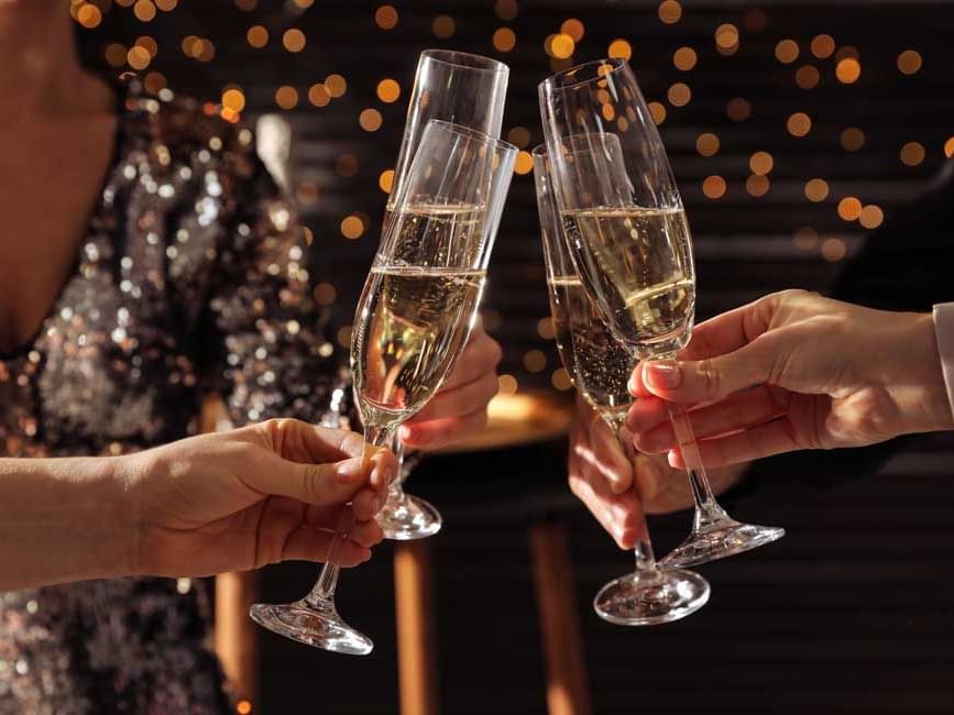 People making a toast with a glass of champagne in hand