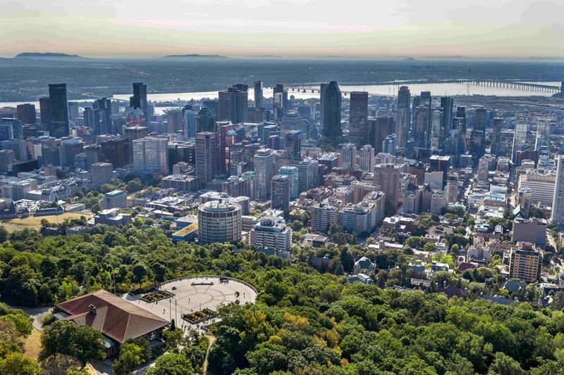 Aerial view of Montreal skyline with downtown buildings, waterfront, and green parkland at Warwick Le Crystal Montreal