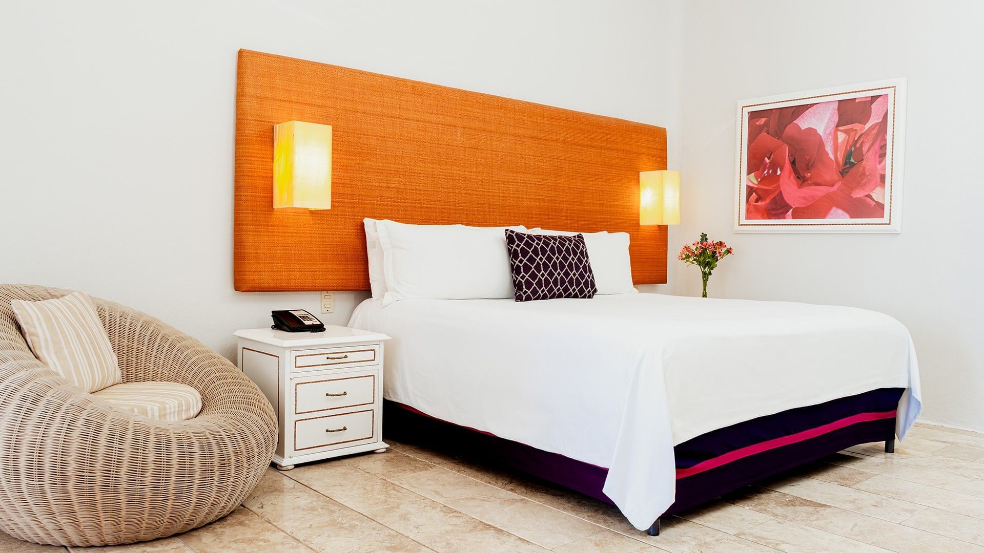 Nightstand and cozy lounge chair by the bed with cushioned headboard in King Deluxe Bed at Camino Real Zaashila Huatulco