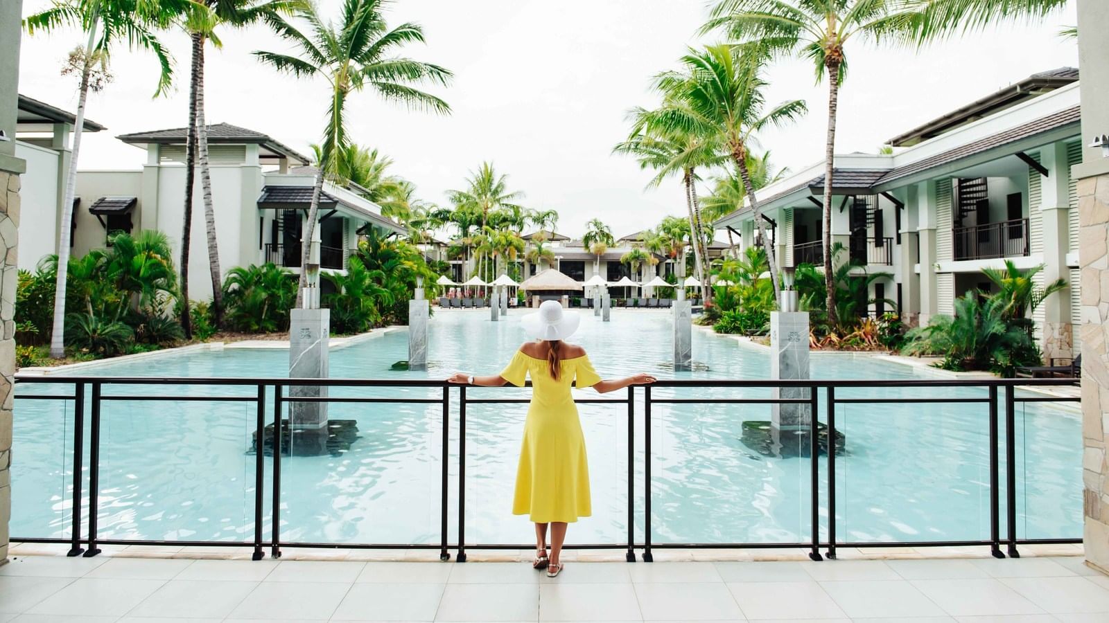 Gril with a hat enjoying the pool view at Pullman Port Douglas Sea Temple Resort & Spa