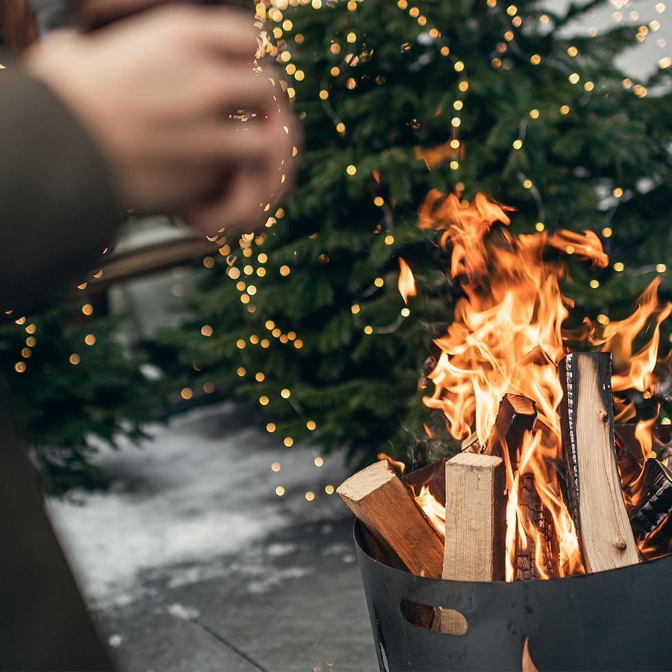 Fire burns in a brazier by Christmas tree at Falkensteiner Hotel Antholz