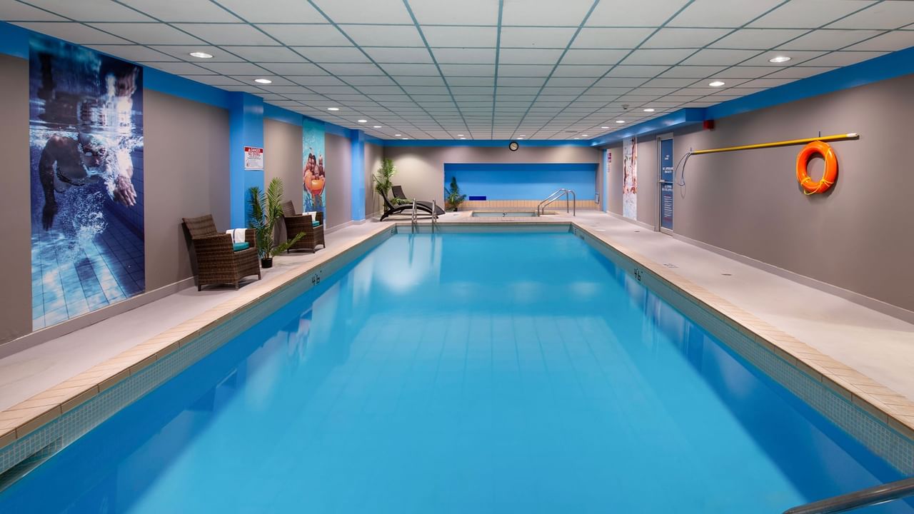 Indoor swimming pool in Coast Prince George Hotel by APA with lounge chairs