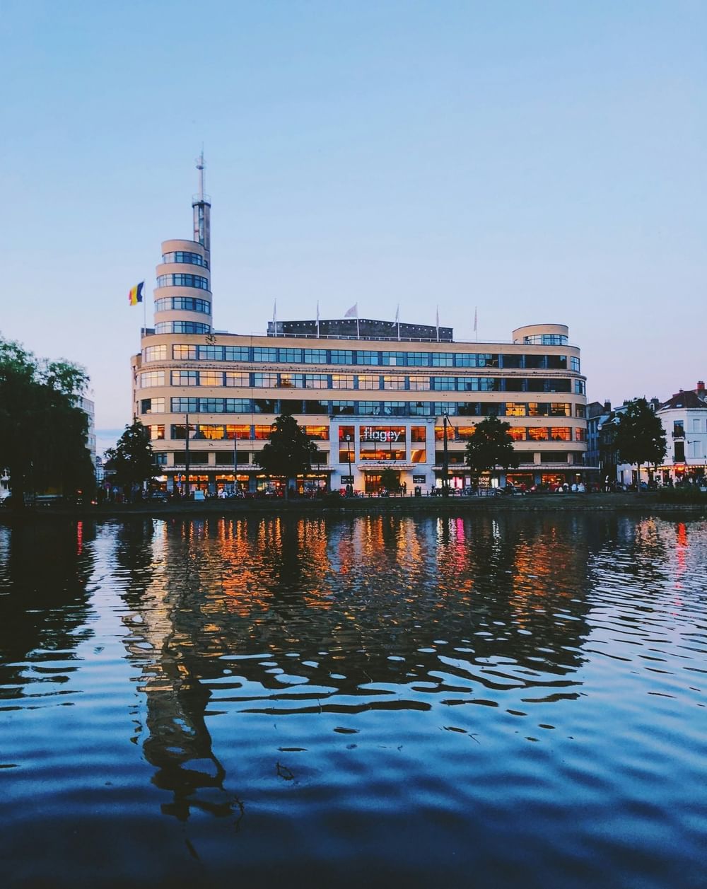 Flagey Building reflecting in water at sunset with Belgian flag at Hotel Barsey by Warwick