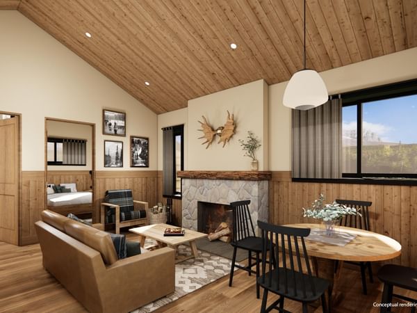 Cabin interior with wood ceiling, fireplace, dining area, and mountain views.