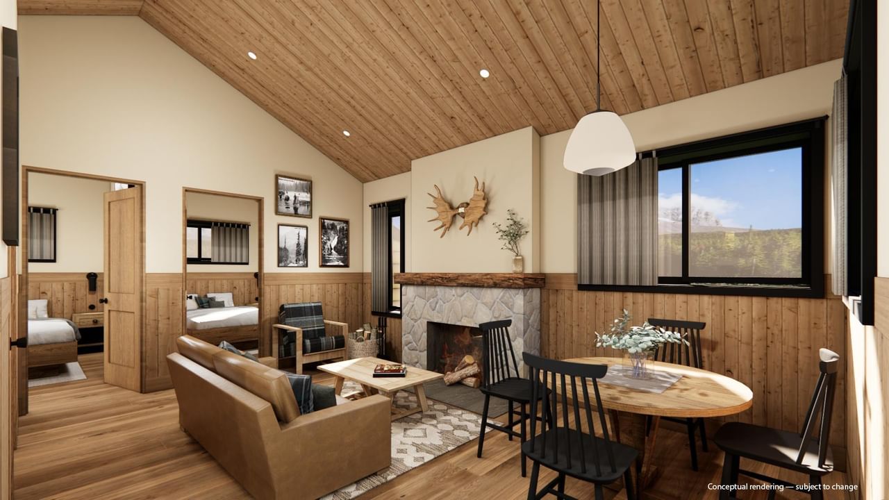 Cabin interior with wood ceiling, fireplace, dining area, and mountain views.