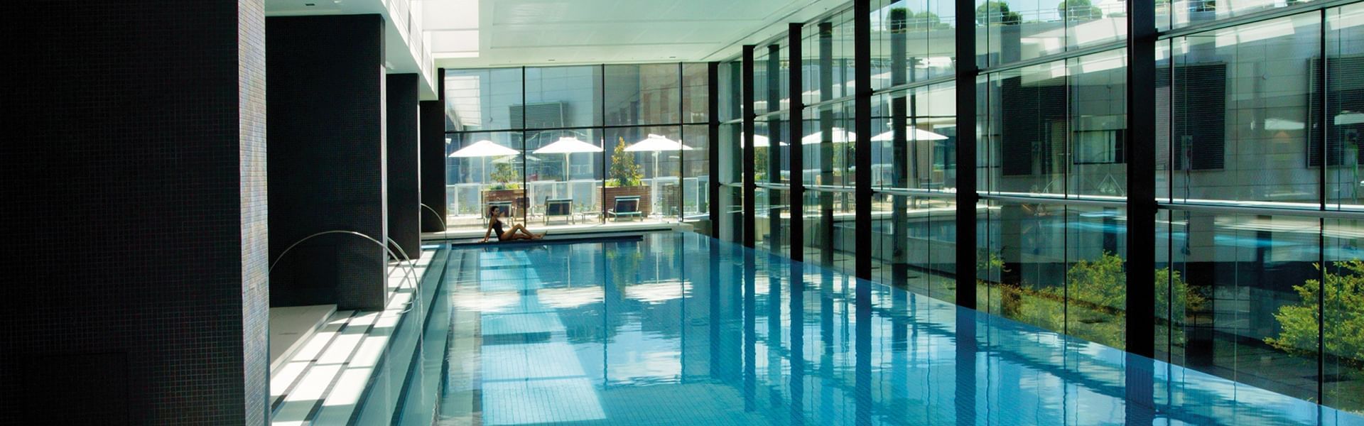 Indoor pool with lounge chairs at Crown Hotels