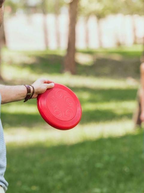 Couple playing frisbee in the garden with a flying disc at Cove Pocono Resorts