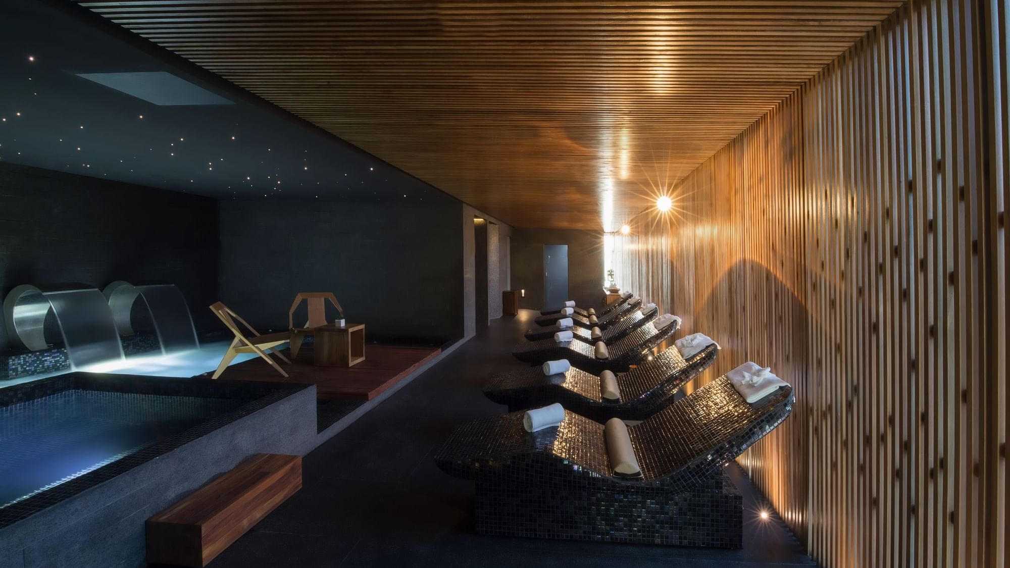 Illuminated spa room interior with amenities on loungers by bathtub at Live Aqua Resorts and Residence Club