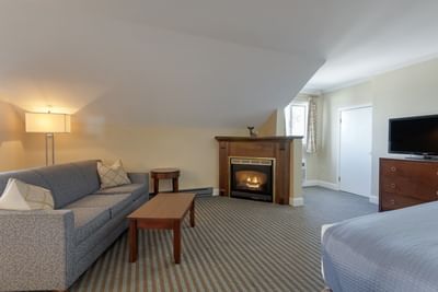 TV lounge area with carpeted floors in Deluxe King Fireplace Room at Union Bluff Hotel