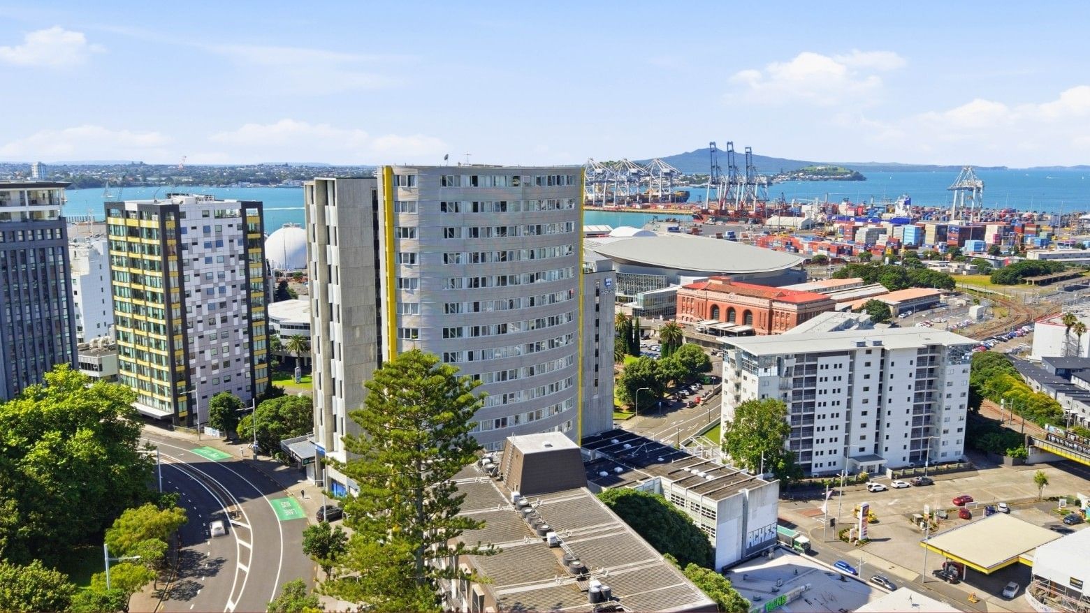 Elevated view of Student Living Auckland Beach building among other structures and a waterfront.