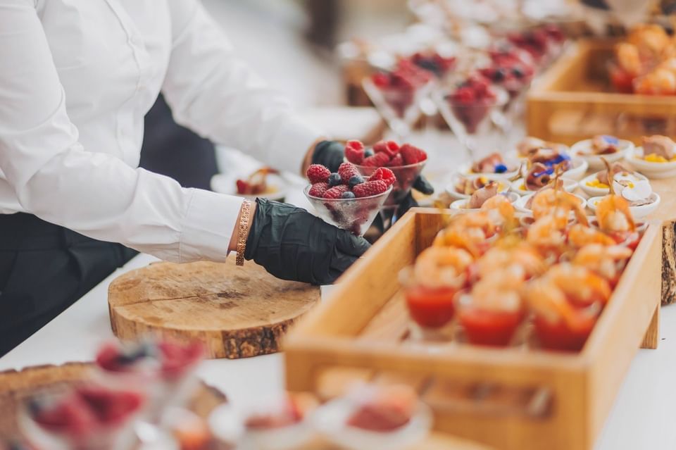 Server arranging colourful berries and shrimp appetisers at a lavish reception buffet at The Met Hotel Leeds, England