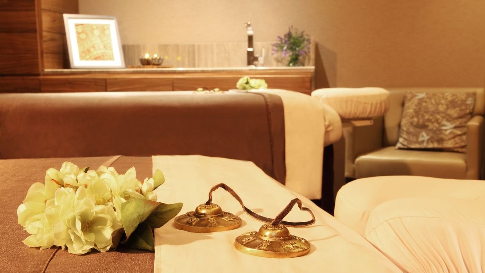 Close-up of tingsha bells in a spa bed at Live Aqua Resorts