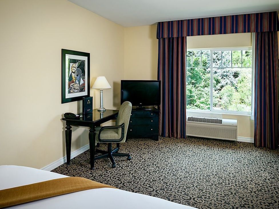 Work area with TV in Cascade King room by Plaza Inn & Suites at Ashland Creek​