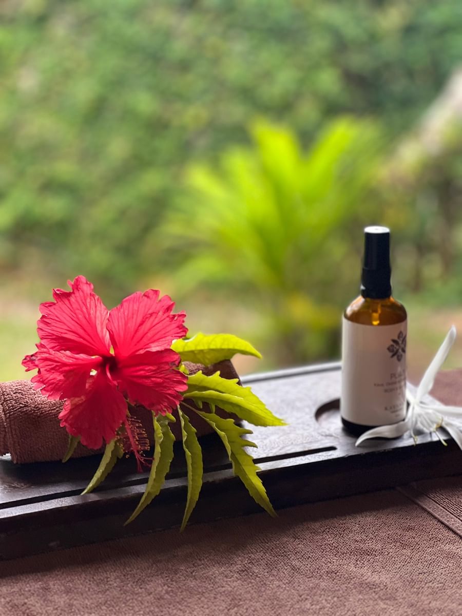 Towel, hibiscus flower, and spray bottle on a wooden tray at Warwick Le Lagon - Vanuatu.