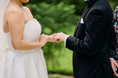 A romantic moment as a groom places a ring on his bride's finger at the Royal on the Park Hotel