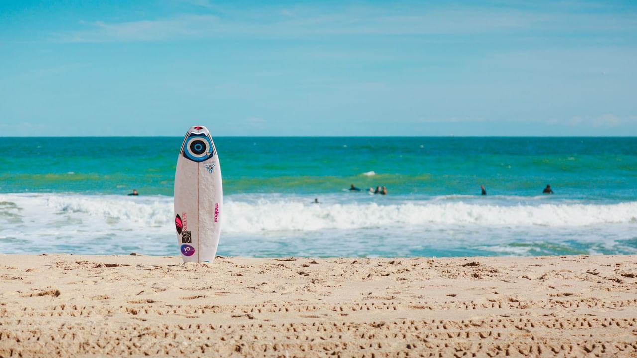 Surfboard in sand next to ocean