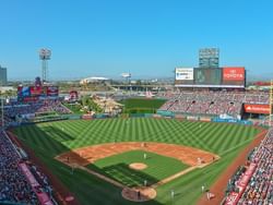 A packed Angel Stadium during a baseball game with players on the field.