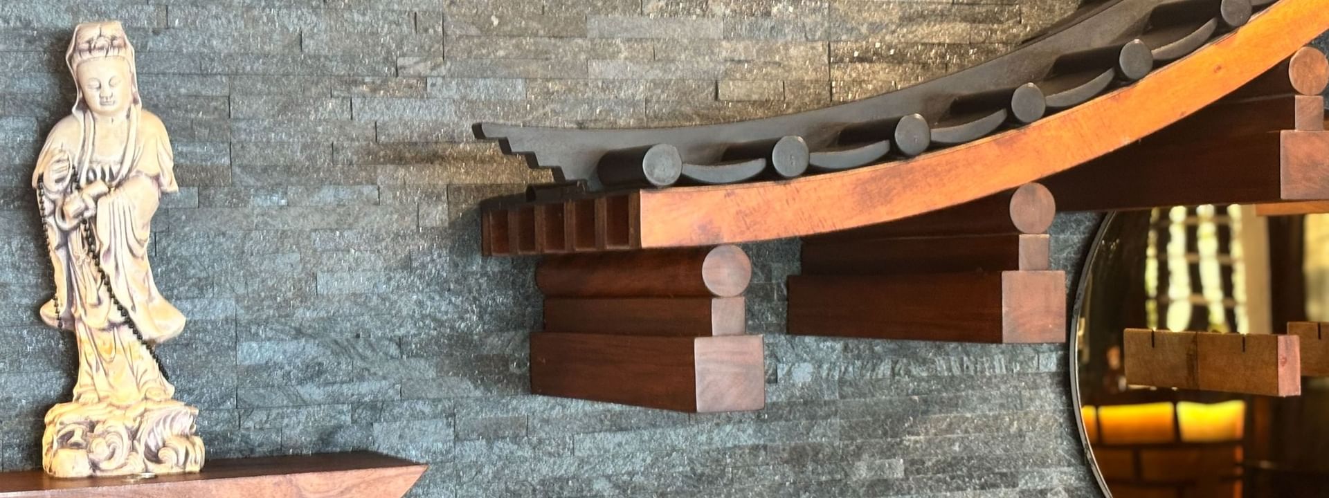 Wall with a Buddha statue and wooden structure at Sazanami in Korolevu at Warwick Fiji Resort and Spa