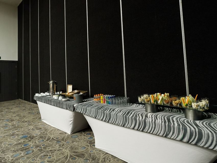 Roma long coffee break station featuring snacks, beverages, and fresh vegetable crudités on platters at Real Inn Tijuana