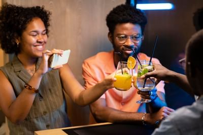 Friends posing & toasting with cocktails at Azalai Hotel Dakar