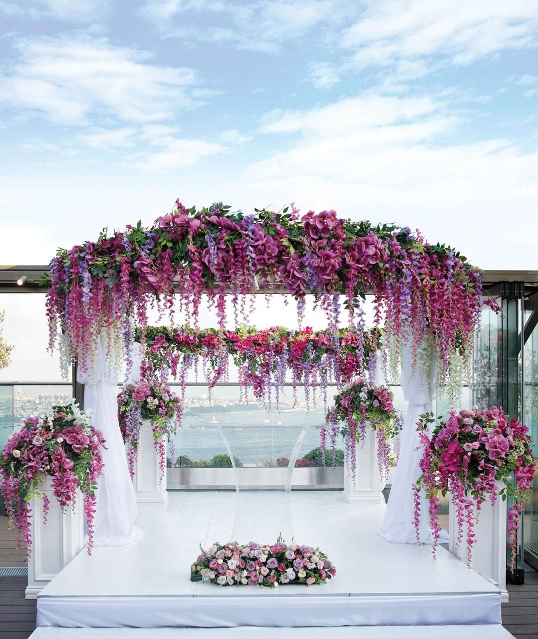 Outdoor wedding arch arranged with a purple floral decor overlooking the sea near CVK Hotels