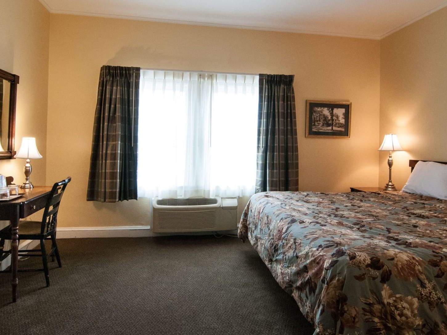 Large bed, workspace & nightstand in Fairway Room at The Bethel Inn Resort & Suites
