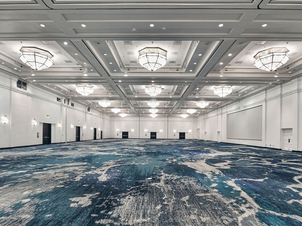 Spacious interior of Grand Caribbean Ballroom with chandeliers & carpeted floors at Las Casitas Village