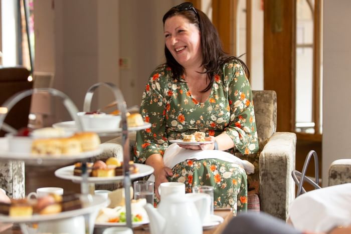 A lady enjoying afternoon tea at Bridgewood Manor Hotel