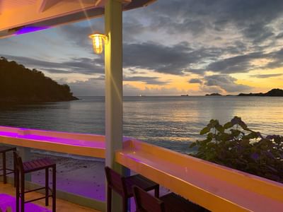  Emerald Beach Bar seating along an open terrace overlooking a peaceful ocean sunset at Emerald Beach Resort
