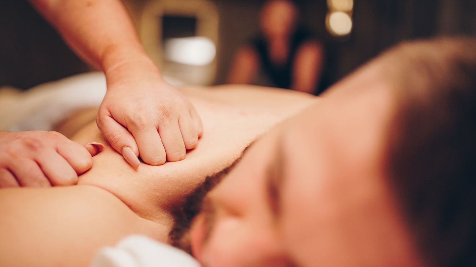 Man receiving a back massage in spa at The Londoner Hotel