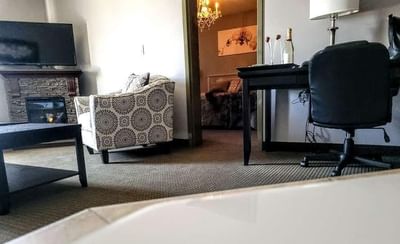 Cozy living room with a work desk & TV in Romantic Spa Suite at Service Plus Inns & Suites Drayton Valley