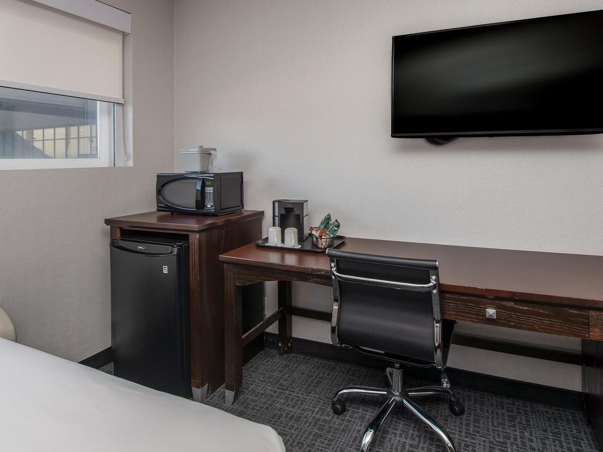 Work desk, TV, mini fridge, and microwave.