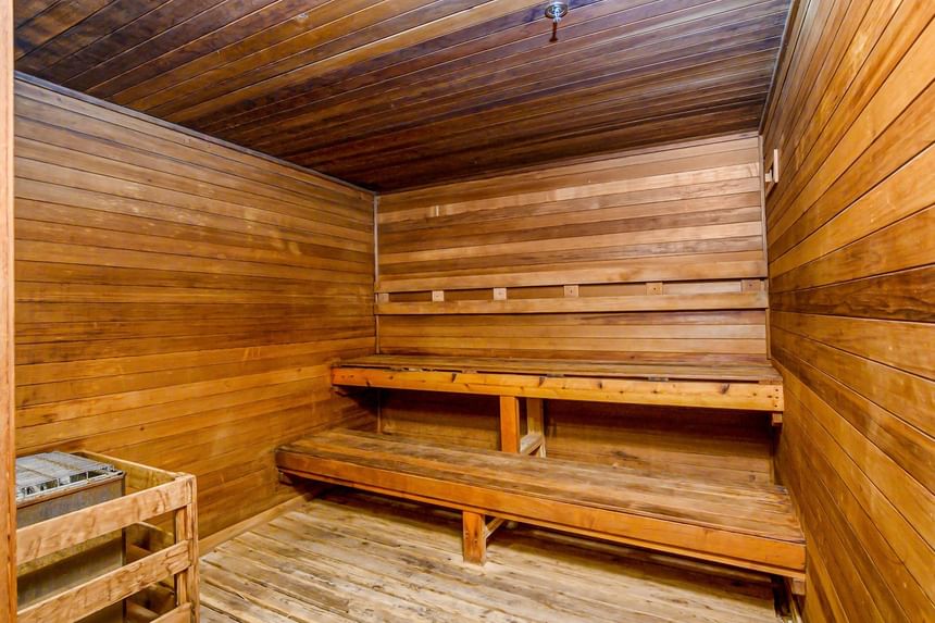 Classic wooden sauna room with tiered bench seating and heater unit at The Atlantic Hotel & Spa