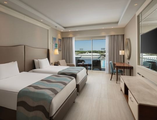 Bright Family Suite Garden with twin beds, balcony, and modern furnishings at Titanic Deluxe Golf Belek, Antalya.