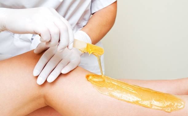 Close-up of a person receiving a leg wax treatment in the spa at Orsett Hall Hotel