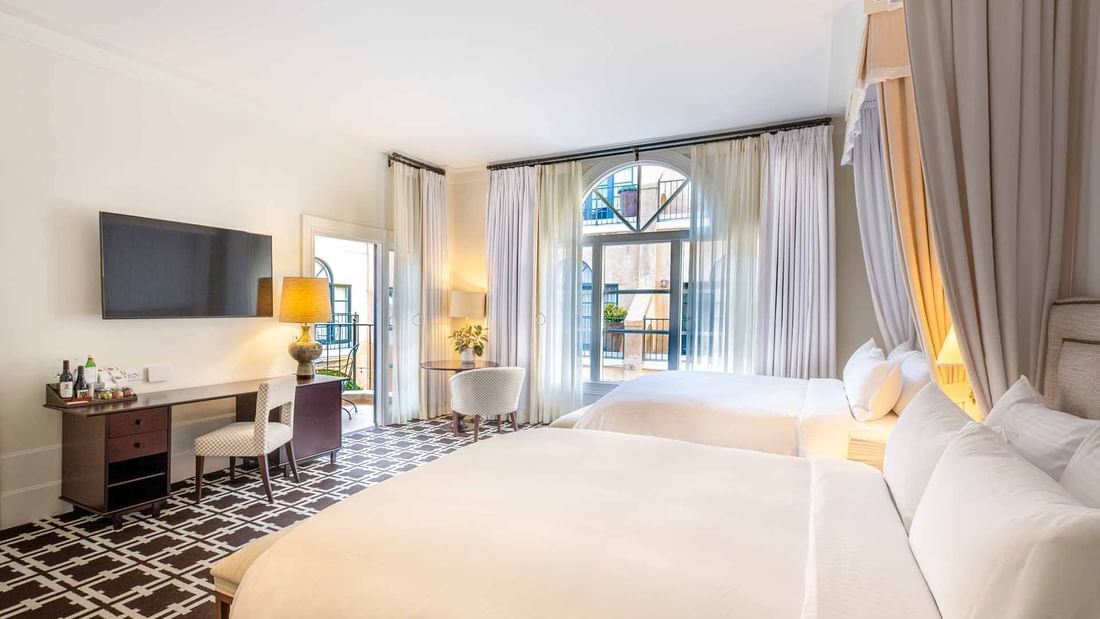 TV and work desk facing the beds in Deluxe Queen Mobility and Hearing Accessible at El Prado Hotel