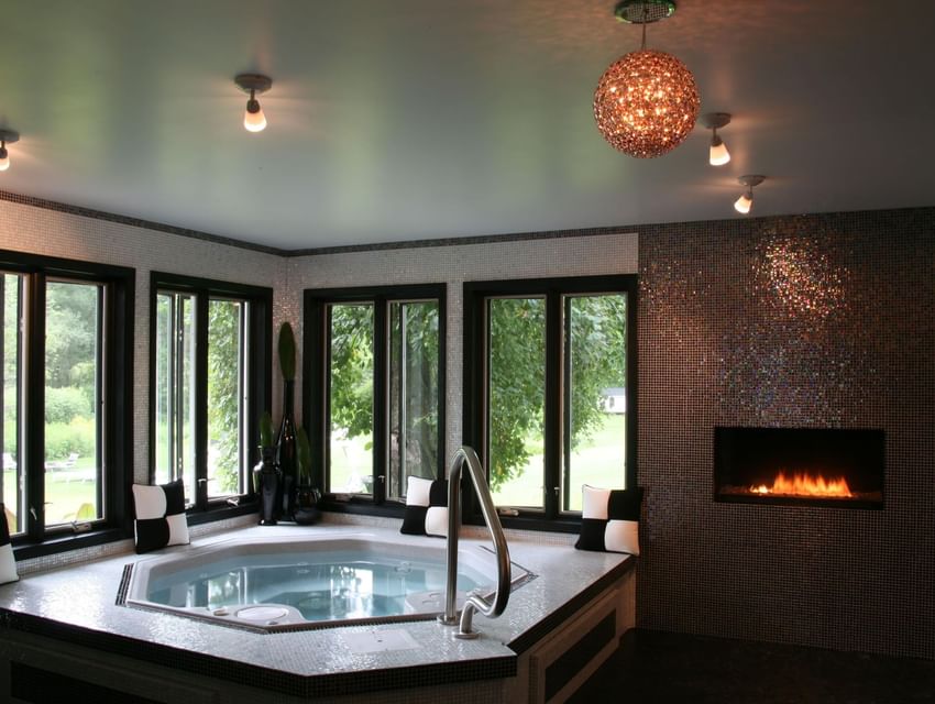 Shimmer Spa South featuring a whirlpool tub, modern decor, and a fireplace at The Roxbury