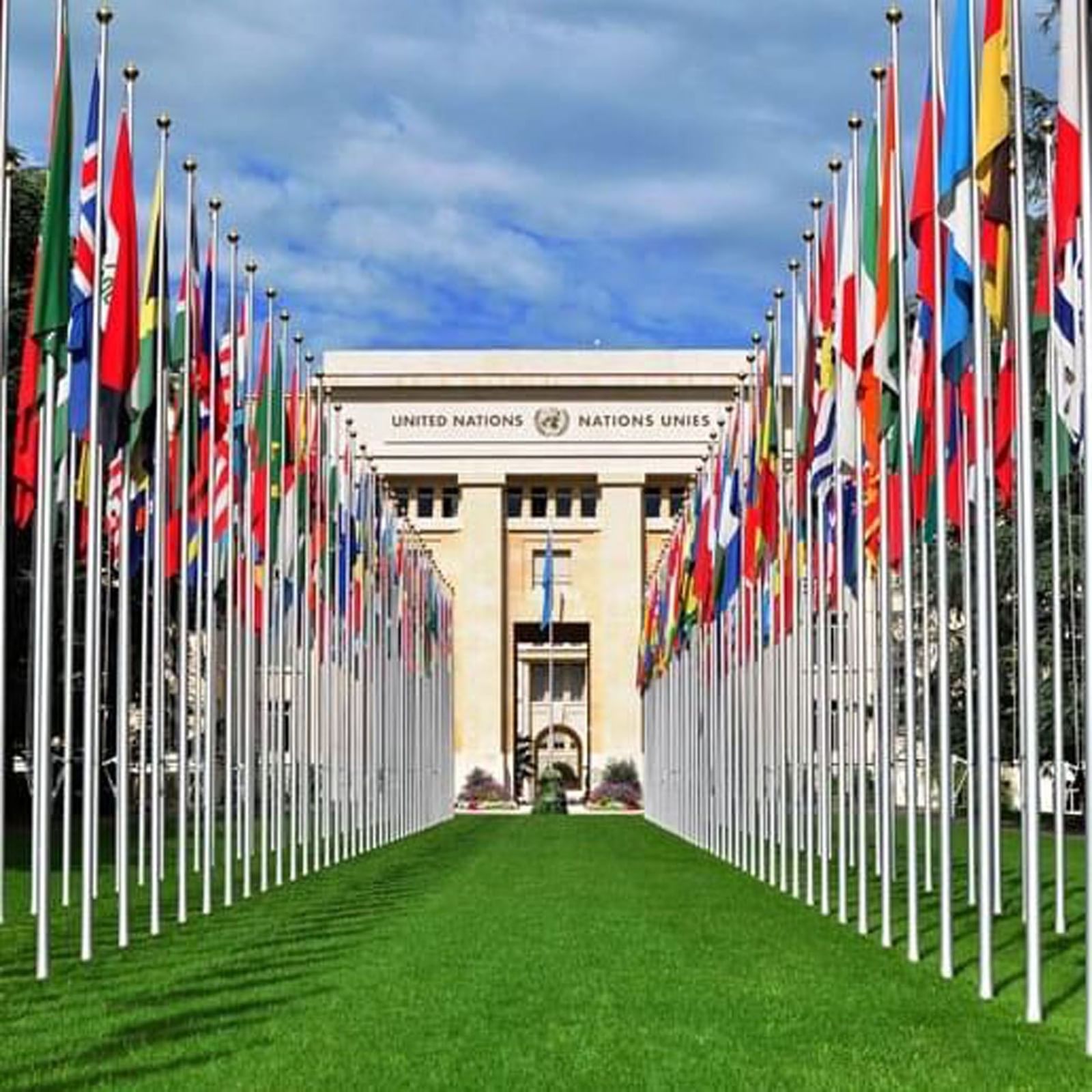 International flags by a green lawn under the Palais des Nations near Warwick Geneva