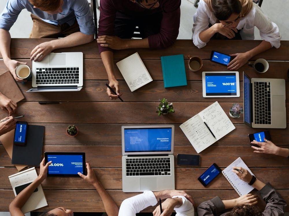 People gathered around a table with laptops & notebooks at Hotel Maya Kuala Lumpur City Centre